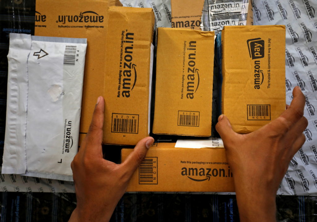 A delivery worker of Amazon carries a packet to deliver it to a customer at a residential apartment in Ahmedabad, India, March 17, 2021.REUTERS/Amit Dave