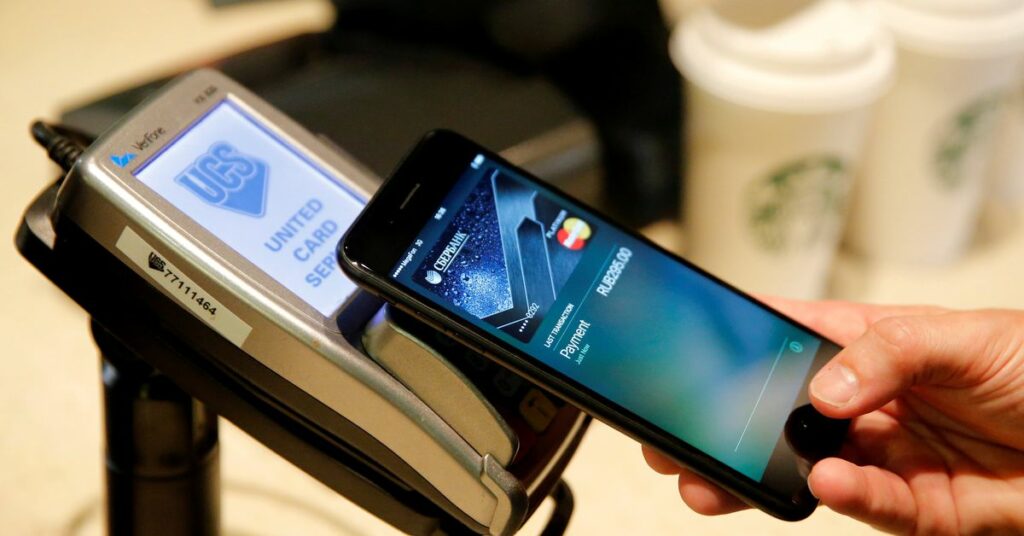 A man uses an iPhone 7 smartphone to demonstrate the mobile payment service Apple Pay at a cafe in Moscow, Russia, October 3, 2016.    REUTERS/Maxim Zmeyev