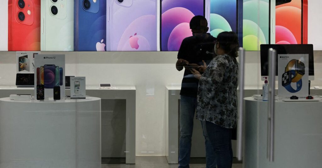 A salesperson speaks to a customer at an Apple reseller store in Mumbai, India September 1, 2021. REUTERS/Francis Mascarenhas/File Photo