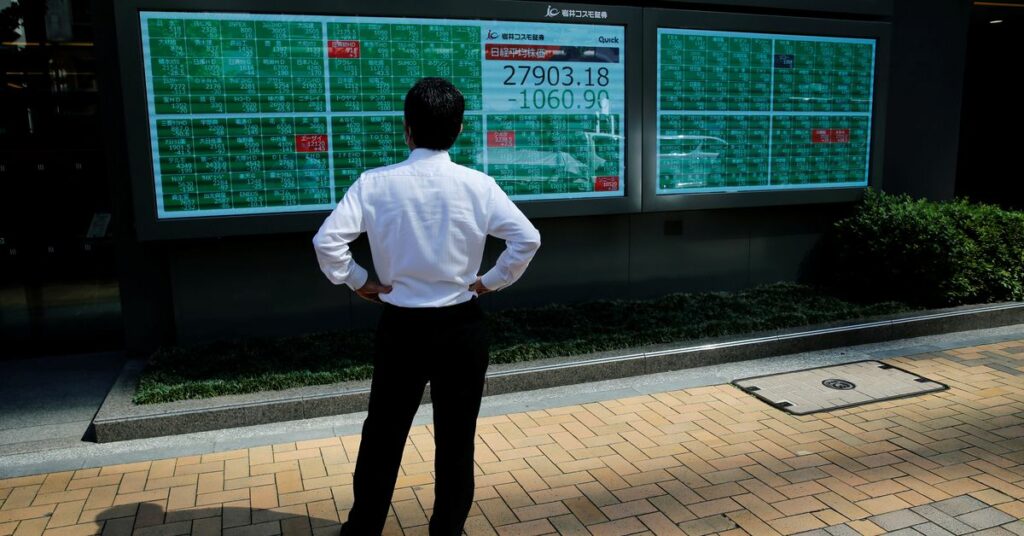 A man watches an electric board showing Nikkei index outside a brokerage at a business district in Tokyo, Japan, June 21, 2021.   REUTERS/Kim Kyung-Hoon