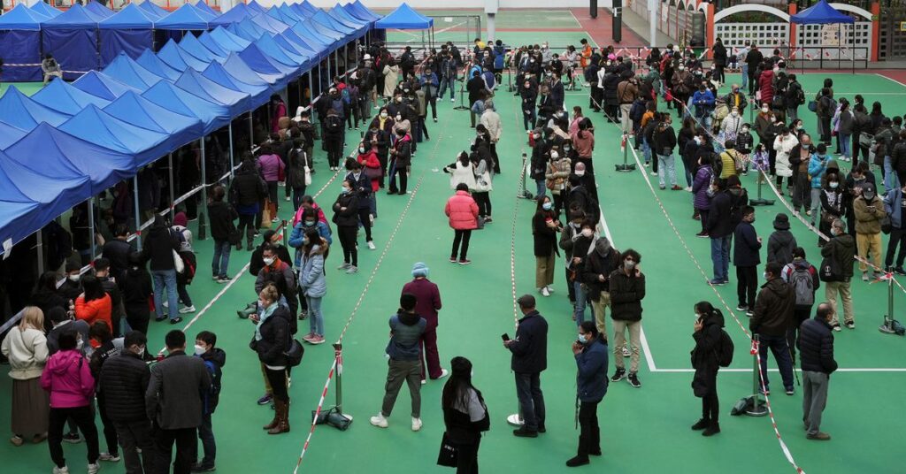 People wearing face masks line up at a testing centre for the coronavirus disease (COVID-19) in Hong Kong, China February 23, 2022. REUTERS/Lam Yik