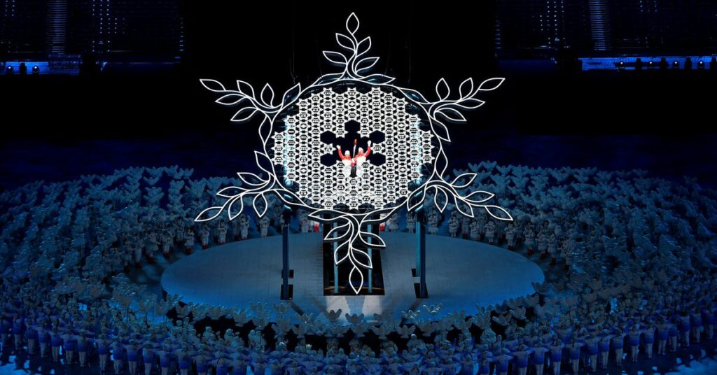 2022 Beijing Olympics - Opening Ceremony - National Stadium, Beijing, China - February 4, 2022. Torchbearers Zhao Jiawen and Dinigeer Yilamujiang hold the Olympic torch during the opening ceremony. REUTERS/Toby Melville/File Photo