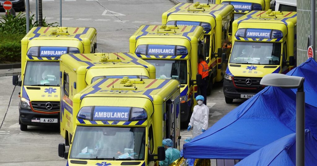 Staff members wearing face masks stand near to a mobile testing vehicle dispatched from mainland China, following the coronavirus disease (COVID-19) outbreak in Hong Kong, China February 18, 2022. REUTERS/Lam Yik