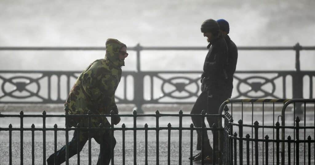 People take pictures as waves break on during Storm Eunice, in Brighton, Britain, February 18, 2022. REUTERS/Peter Nicholls