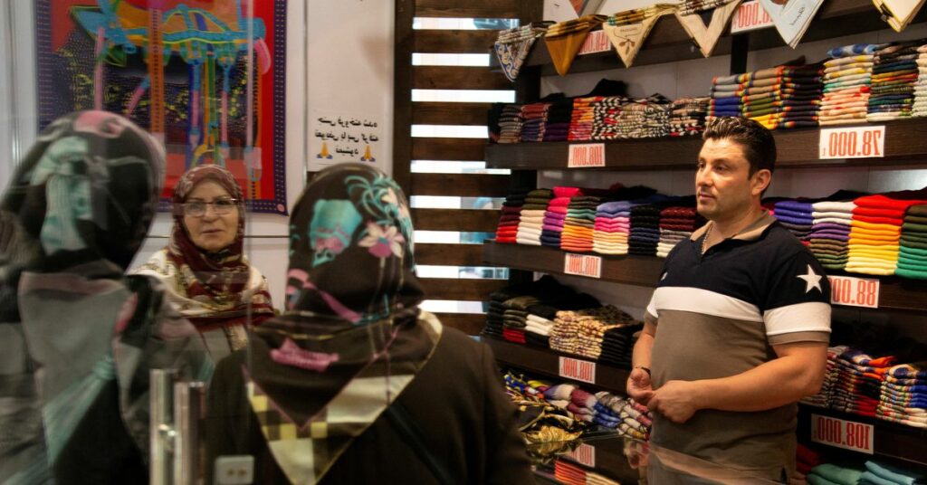 Women shop at a street in Tehran