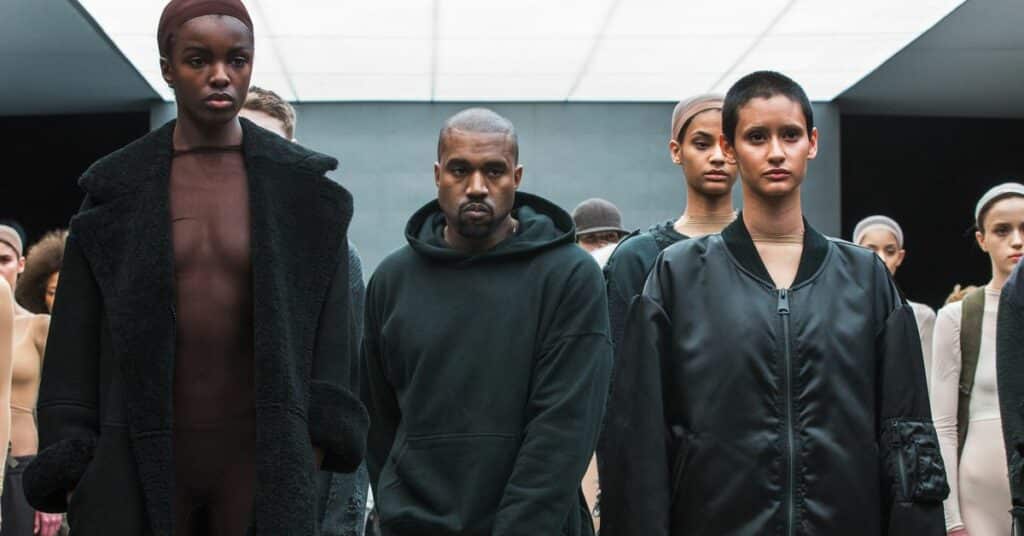 Singer Kanye West walks past models after presenting his Fall/Winter 2015 partnership line with Adidas at New York Fashion Week