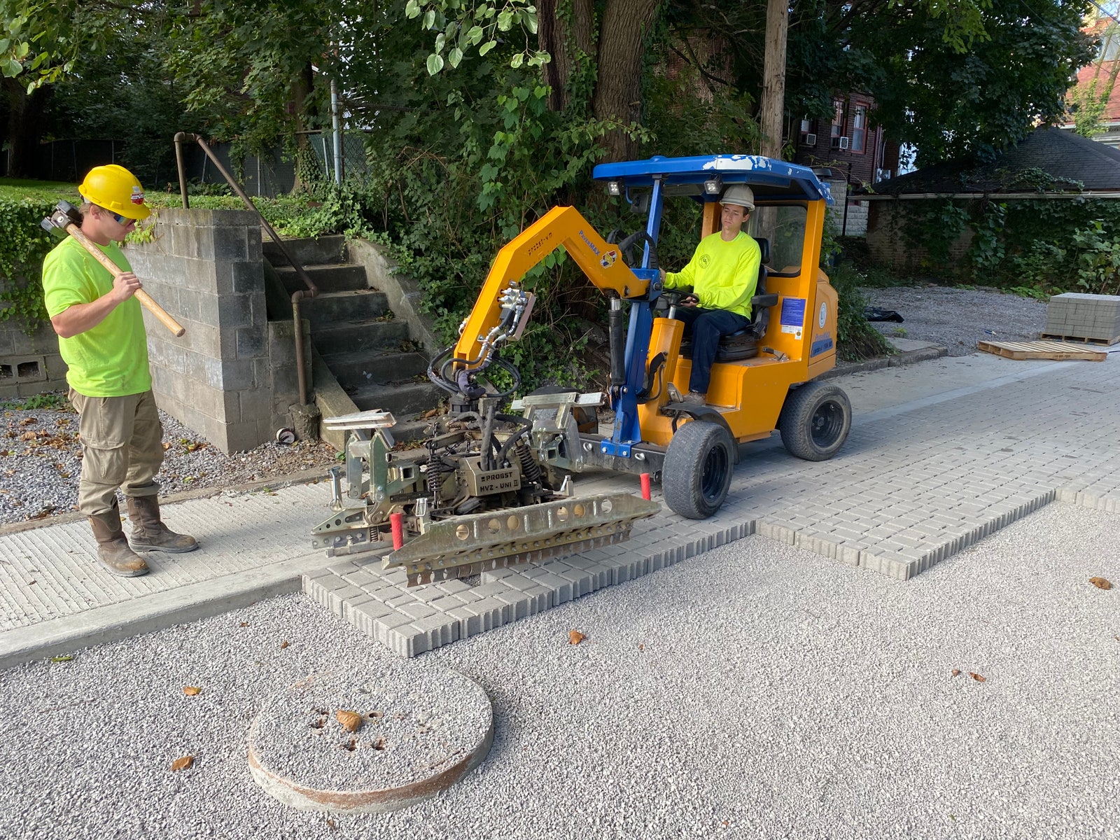 trabajadores de la construcción colocando adoquines