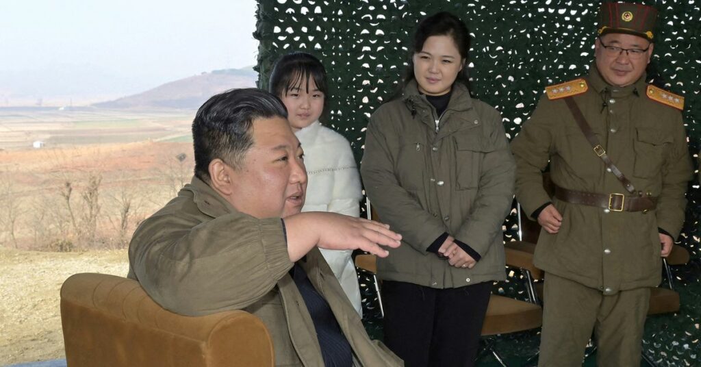 North Korean leader Kim Jong Un, with his wife Ri Sol Ju and their daughter, speaks on the day of the launch of an ICBM in this undated photo released by KCNA