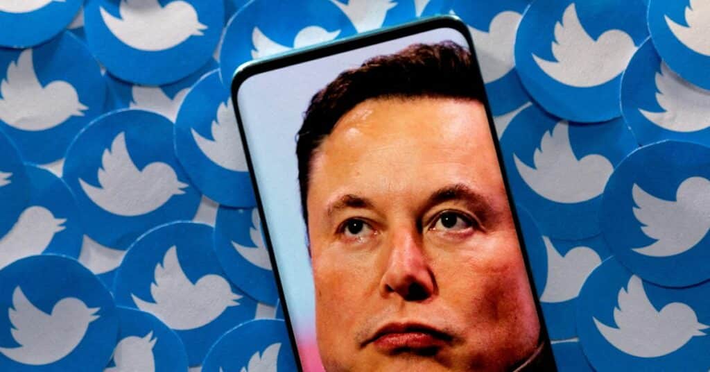 Illustration shows Elon Musk image on smartphone and printed Twitter logos