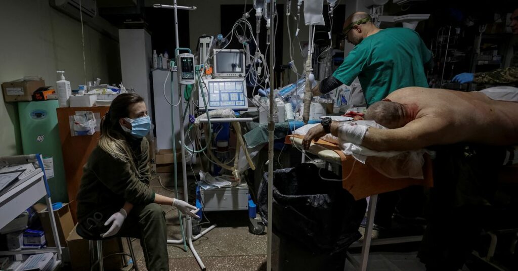 Healthcare workers treat a wounded Ukrainian serviceman in a pre-hospital medical aid centre in Donetsk region