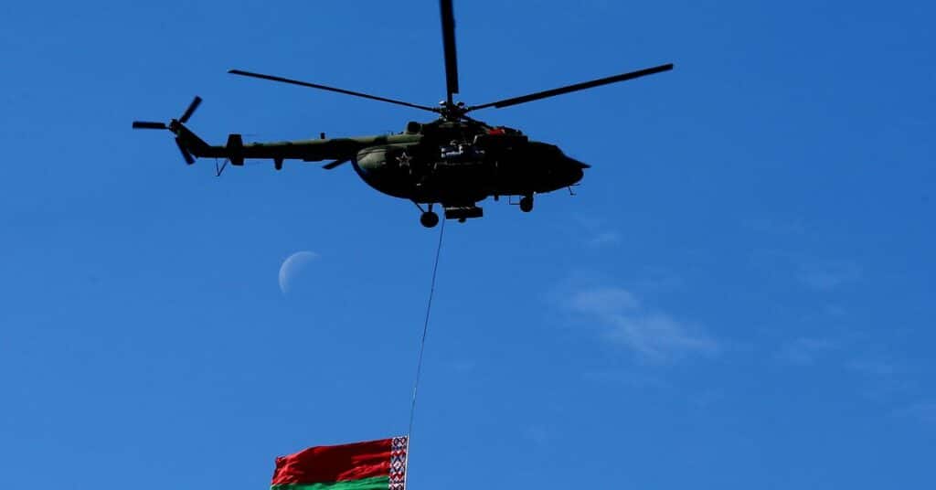 A MI-8 helicopter from the Belarus army carries the Belarussian national flag during the opening ceremony of the 8th International Exhibition of Arms and Military Machinery "MILEX 2017" in Minsk