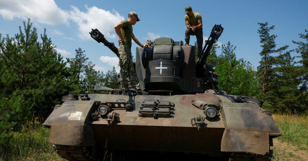 Ukrainian servicemen speak to each other atop a Gepard self-propelled anti-aircraft gun during their combat shift in Kyiv region