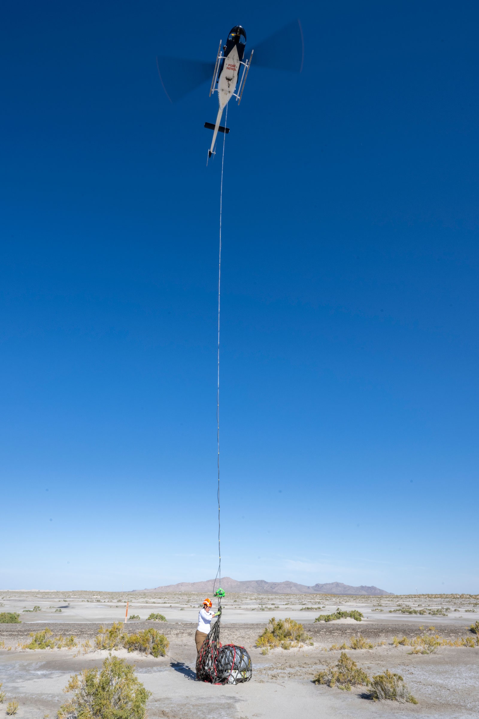 tripulación adjuntando muestra de regreso al helicóptero