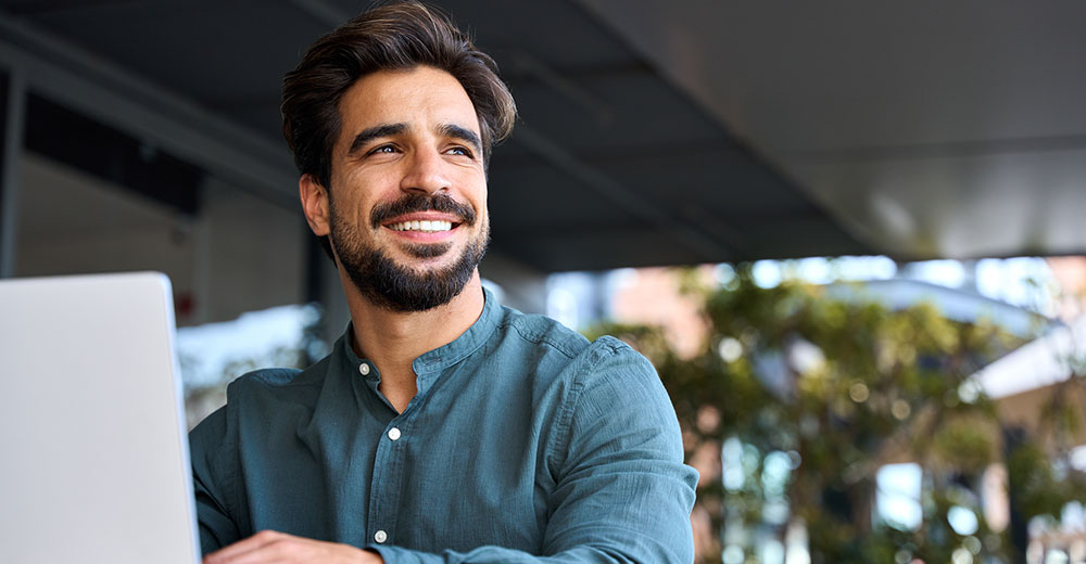 happy young business man using the internet showing no negative affects on his mental health